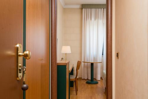 a room with a desk and a table with a lamp at Hotel San Francesco in Rende