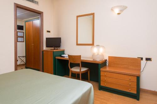 a bedroom with a bed and a desk with a mirror at Hotel San Francesco in Rende