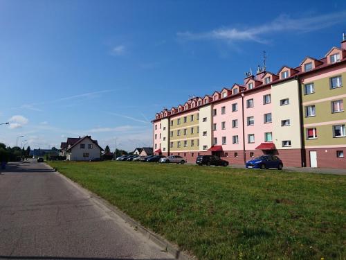 a large building with cars parked in front of it at Apartament BRYZA in Darłowo