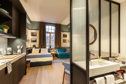 a bathroom with a sink and a living room at Getaway Studios Gent in Ghent