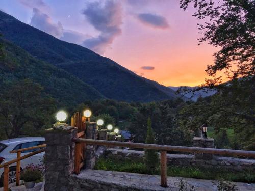 a fence with a view of a mountain at sunset at Chalet Kujta in Peje