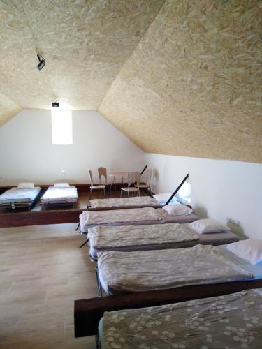 a row of beds in a room with a ceiling at Penzion Pivovar Podlesí in Příbram