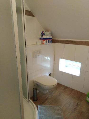 a small bathroom with a toilet and a window at Penzion Pivovar Podlesí in Příbram