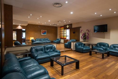 a waiting room with blue leather furniture and a flat screen tv at Hotel San Francesco in Rende