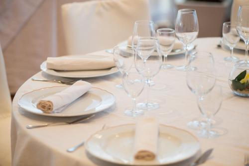 a table with wine glasses and plates and napkins at Hotel San Francesco in Rende