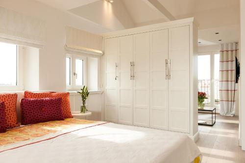 a bedroom with a bed and a large white cabinet at Hotel Sylter Zollhaus in Westerland (Sylt)