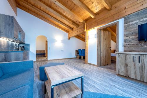 a living room with a blue couch and a table at B&B Appartement Das Stoaberg in Leogang