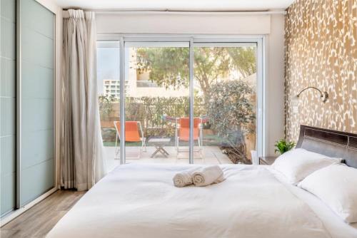 um quarto com uma cama grande e toalhas em Garden Apartment Herzliya Marina. Pool & Gym em Herzliya B