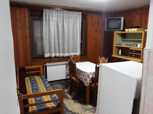 ein Esszimmer mit Tisch und Stühlen und einem Fernseher in der Unterkunft Triangle in Sarajevo