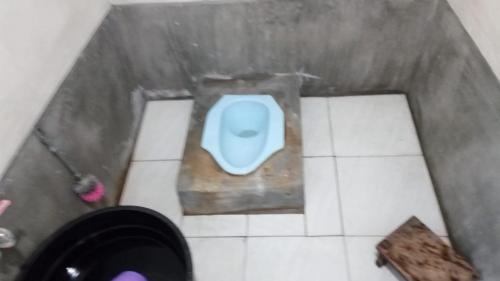 een badkamer met een blauw toilet erboven bij Mudung Keramat Homestay in Sapit