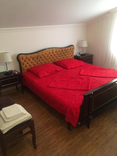 a bedroom with a large red bed with two night stands at Guest House Mtskheta in Mtskheta