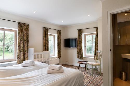 a hotel room with two beds and a tv at Bosvilla Kennemerduinen in IJmuiden
