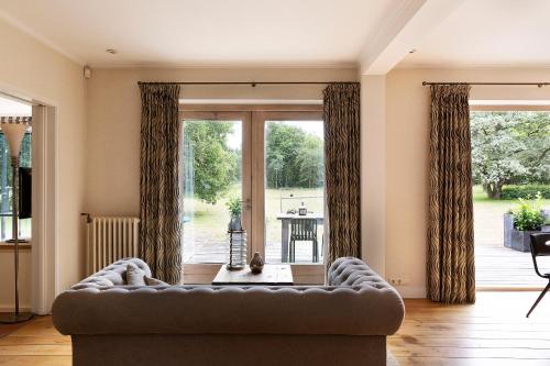 a living room with a couch and a large window at Bosvilla Kennemerduinen in IJmuiden