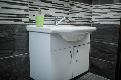 a bathroom with a white sink and a black wall at Twins Apartments in Kato Pyrgos