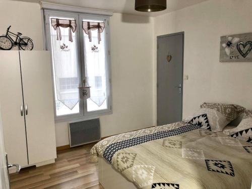 una camera con un letto e due finestre di Appartement Aventure à Épernay a Épernay