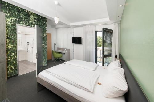 ein Schlafzimmer mit einem weißen Bett und einer grünen Wand in der Unterkunft Hotel INNdependence in Mainz
