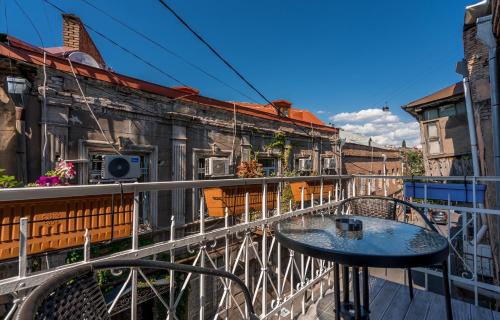a table on the balcony of a building at Golden Light Hotel in Tbilisi City