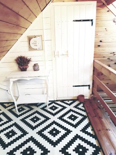 a room with a white door and a black and white rug at Dom z bali w Rycerce Górnej in Rycerka Górna