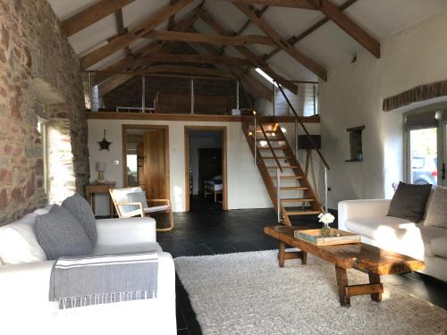 a living room with a white couch and a table at Dan y Graig Barn, Carmarthen in Carmarthen