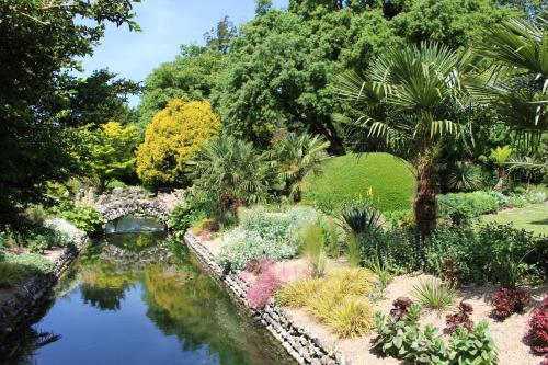 a garden with a pond and a bridge at West Dean College in West Dean