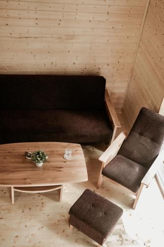 a living room with a couch and a coffee table at Atpūtas Bāze Ods LOFTS in Bārta