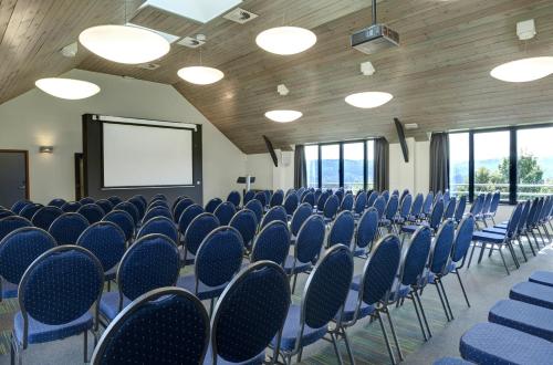 a conference room with blue chairs and a screen at Azur en Ardenne in Durbuy