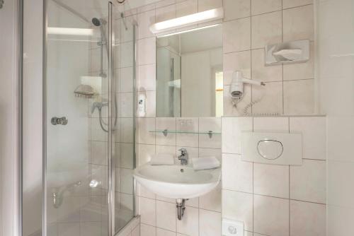 a bathroom with a sink and a shower at AHORN Berghotel Friedrichroda in Friedrichroda