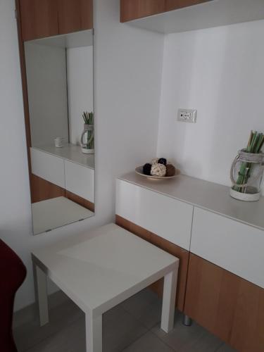 ポリニャーノ・ア・マーレにあるLa Dimora del Gelso Rossoの白いテーブルと白いベンチが備わるお部屋です。