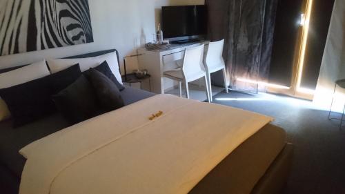 a bedroom with a bed and a desk and a television at K82 BNB & Hotel in Kirchentellinsfurt