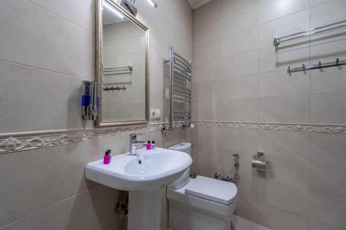 a bathroom with a sink and a toilet and a mirror at Golden Light Hotel in Tbilisi City