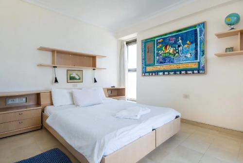 a bedroom with a large bed and a painting on the wall at Panoramic Sea-View Suite in Haifa