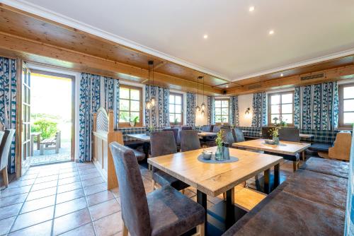 a restaurant with wooden walls and tables and chairs at B&B Appartement Das Stoaberg in Leogang