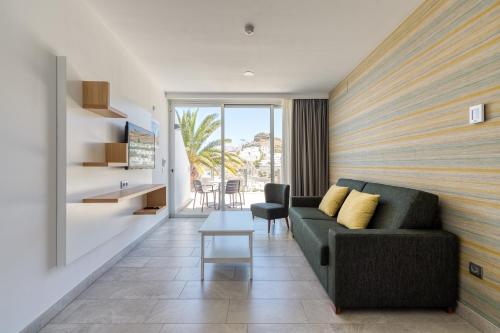 a living room with a couch and a table at Holiday Club Puerto Calma in Puerto Rico de Gran Canaria