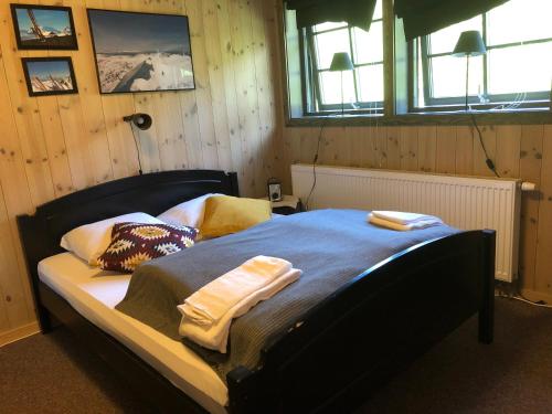 GaustablikkにあるDen Lykkelige Sportsmannのベッドルーム1室(ベッド1台、タオル2枚付)