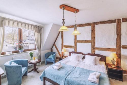 ein Schlafzimmer mit einem Bett und zwei blauen Stühlen in der Unterkunft COLUMBUS Ustka - Limanowskiego 1 in Ustka