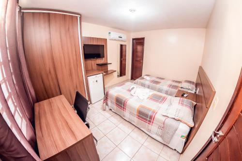 a small room with a bed and a kitchen at Pousada e Pensionato Dona Rosa - Crato,CE in Crato