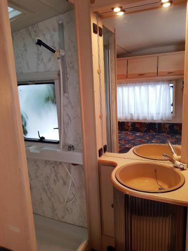 a bathroom with two sinks and a window at Przyczepy Kemping Polaris Półwysep Helski in Chałupy