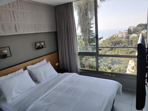 1 dormitorio con cama y ventana grande en Luxury Suites by Notaly Ariel en Haifa