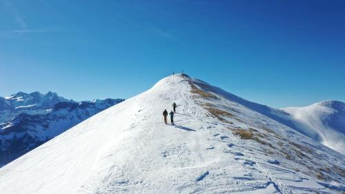two people standing at the top of a snow covered mountain at Emma's B&B - Self Check-in Hotel in Lungern