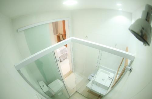 a small white bathroom with a sink and a toilet at Pousada Ravenalas - Apartamentos e Flats in Barra Grande