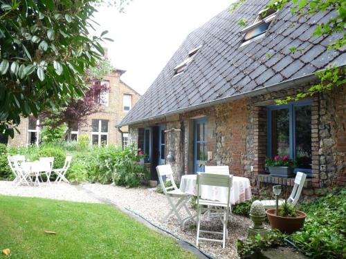 a house with a table and chairs in the yard at Studio duplex L'Ecole Buissonnière in Trouville-la-Haule