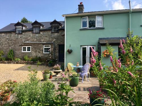 a garden in front of a house with flowers at Brecon Boutique Breaks River Run in Sennybridge