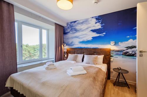 een slaapkamer met een groot bed en handdoeken bij FeWo Prora - Horizont in Binz