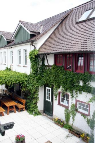 a white house with a green door and ivy at Landhotel Wieseneck in Winterfeld