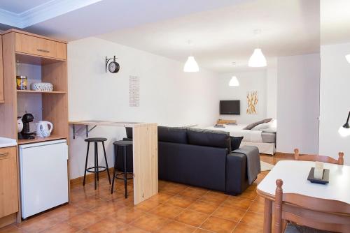 een woonkamer en een keuken met een bank en een tafel bij Espacio tipo estudio completo, totalmente privado e independiente in Erandio