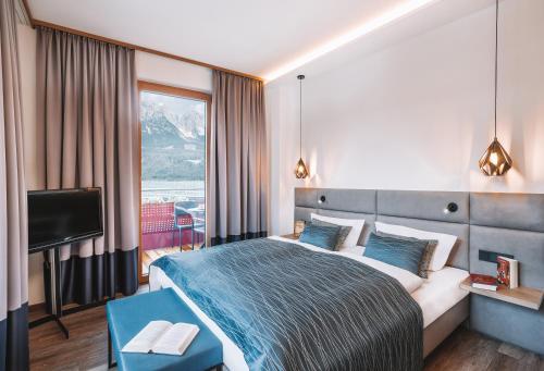 um quarto de hotel com uma cama e uma televisão em Das Kaiserblick 4 Sterne Superior em Ellmau