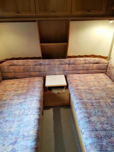a small room with two beds and a table at Przyczepy Kemping Polaris Półwysep Helski in Chałupy