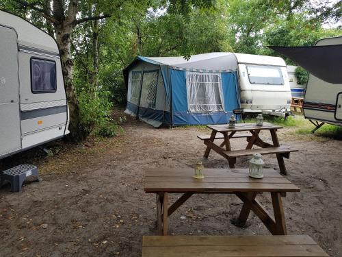 a picnic table in front of a campsite with tents at Przyczepy Kemping Polaris Półwysep Helski in Chałupy