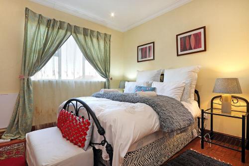a bedroom with a large bed and a window at Natalie Guesthouse in Bloubergstrand