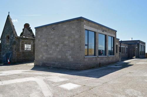 a brick building with glass windows in a parking lot at School house Portaferry in Portaferry